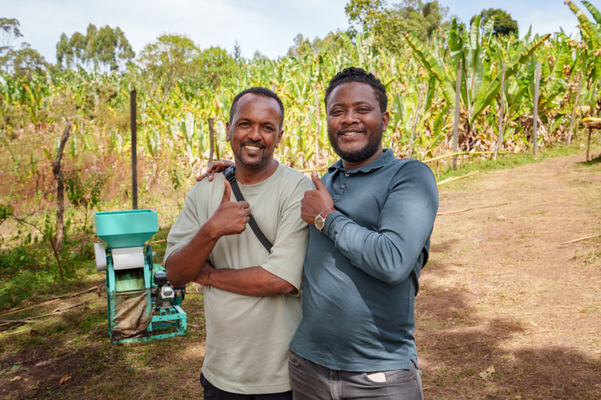 ALO COFFEEの生産者タミル・タデッセ氏と現地のスタッフ。背景には緑豊かなバナナの木などのシェードツリーが広がる。